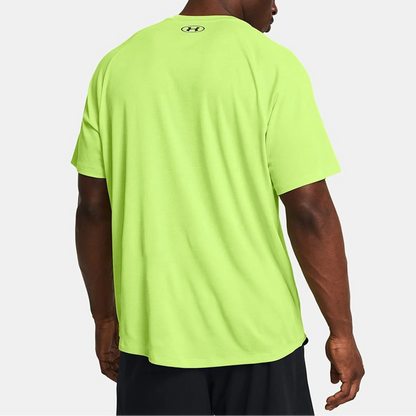 Person wearing a bright green t-shirt with a brand logo on the back, on a white background
