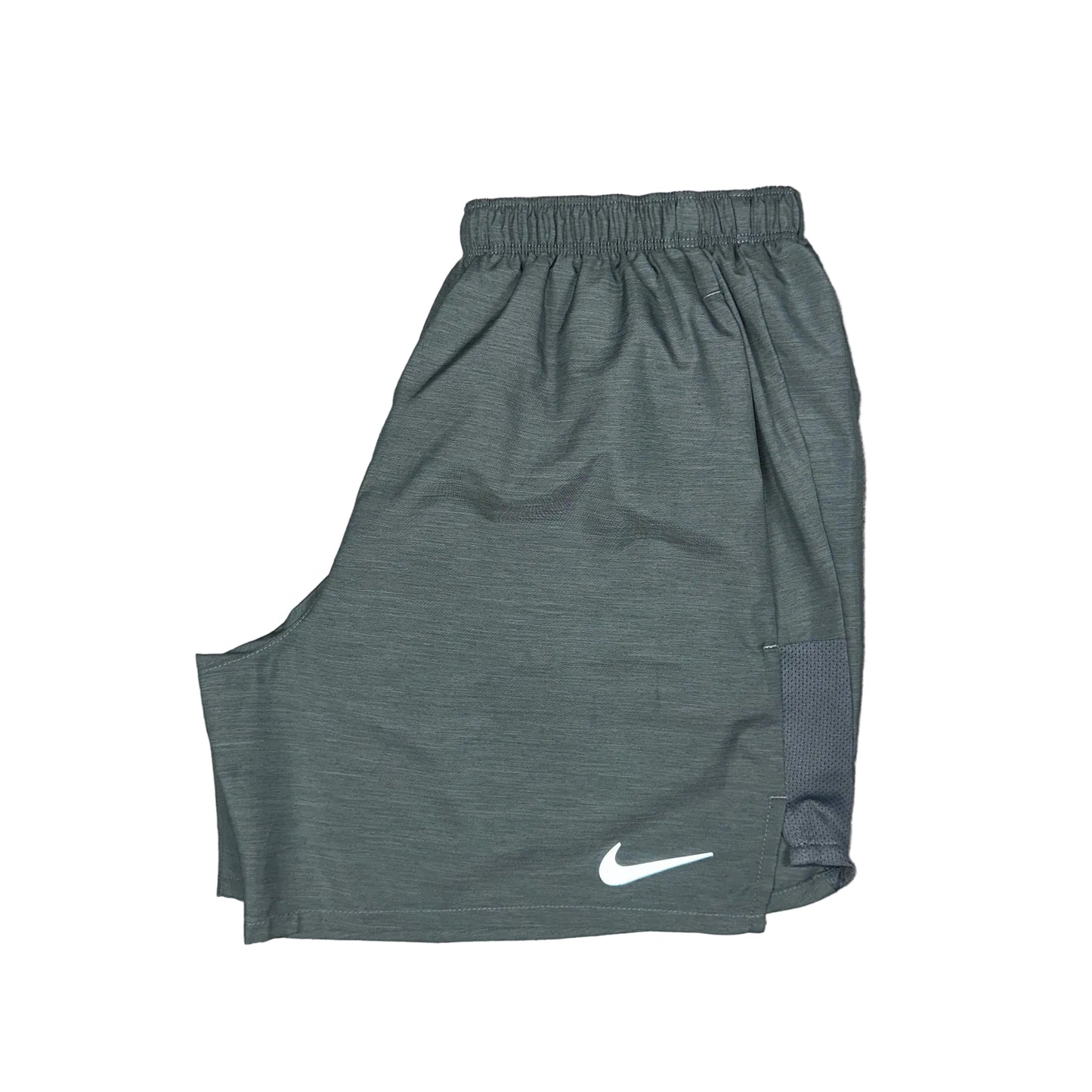 Green athletic shorts with a Nike logo on a concrete surface