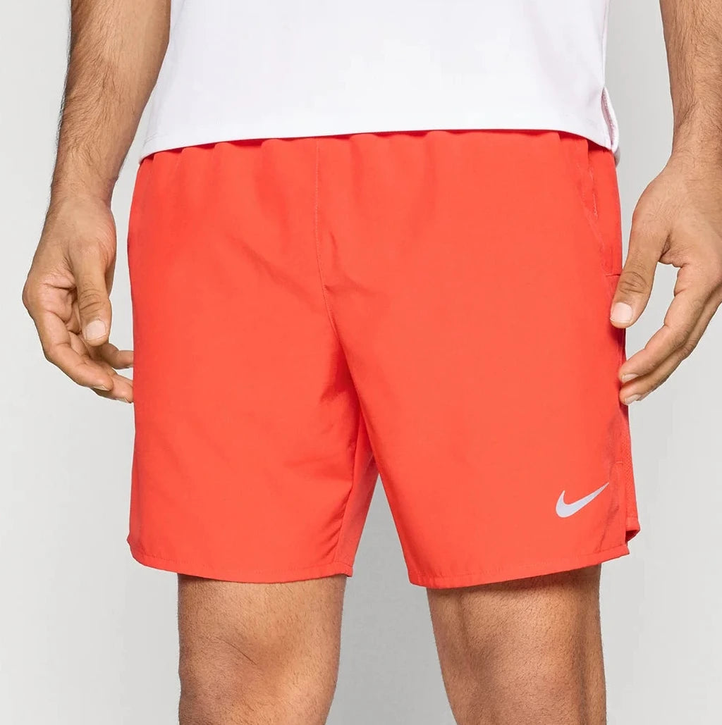 Person wearing bright orange Nike shorts on a white background