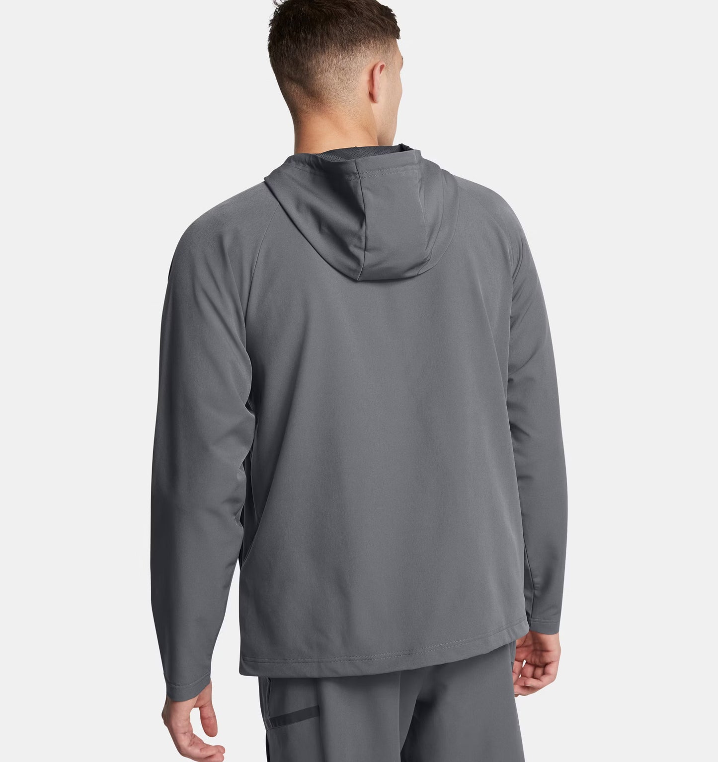 Person wearing a gray hoodie and pants on a white background