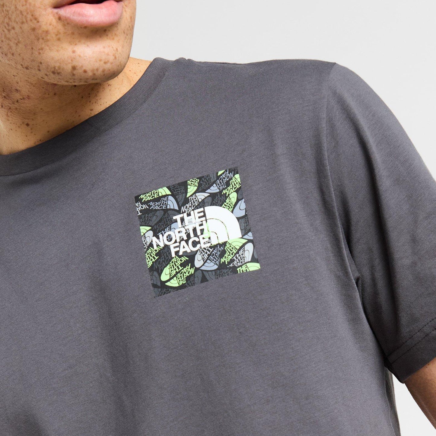 Person wearing a gray t-shirt with The North Face logo