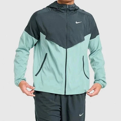 Person wearing a two-tone jacket and pants with Nike logo on a light gray background