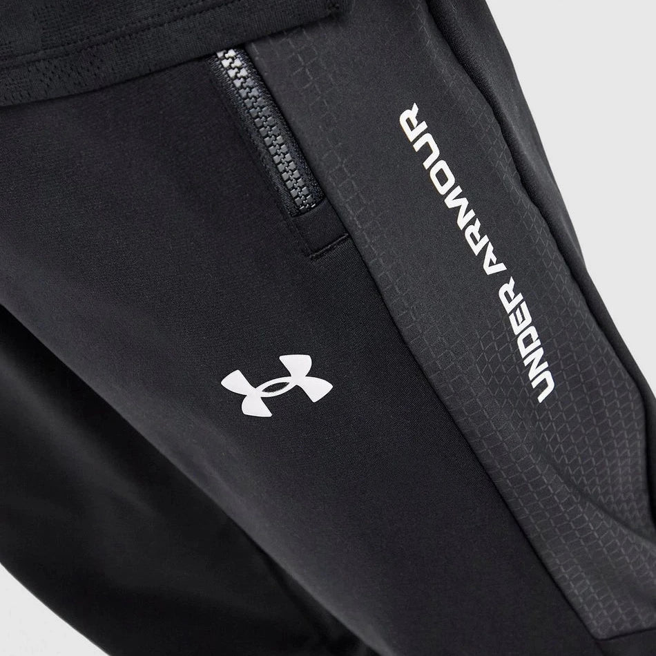 Black pants with Under Armour logo and text on a light gray background