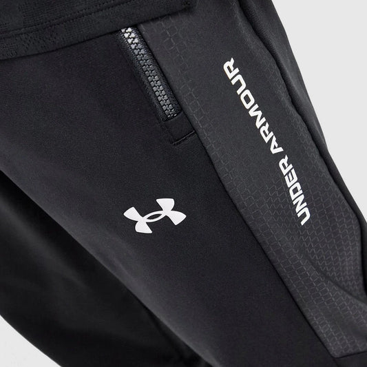 Black pants with Under Armour logo and text on a light gray background