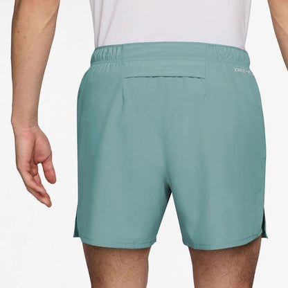 Teal shorts worn by a person on a white background